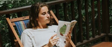 Woman reading a book in the treehouse terrace